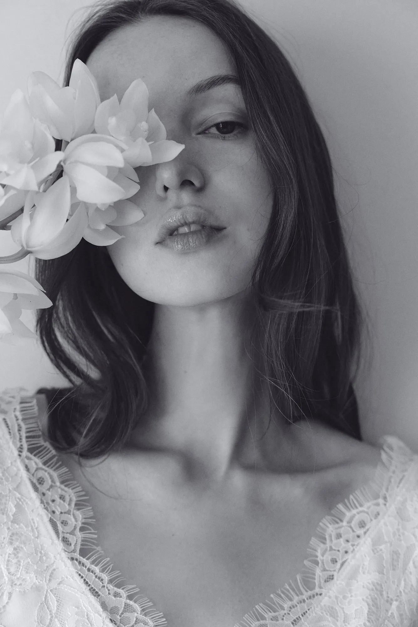 蘭の花を添えたモノクロームのポートレート(公式ブランドサイト素材)